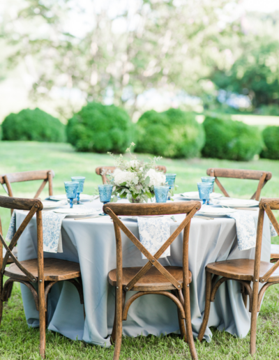 Wedding Table with wooden crossback chairs, light blue tablecloth and hydrangea florals.