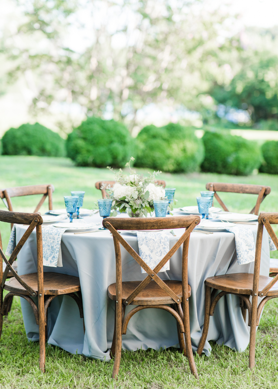 Wedding Table with wooden crossback chairs, light blue tablecloth and hydrangea florals.
